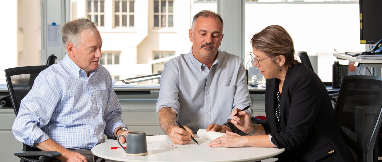 Two men and a woman sitting at table