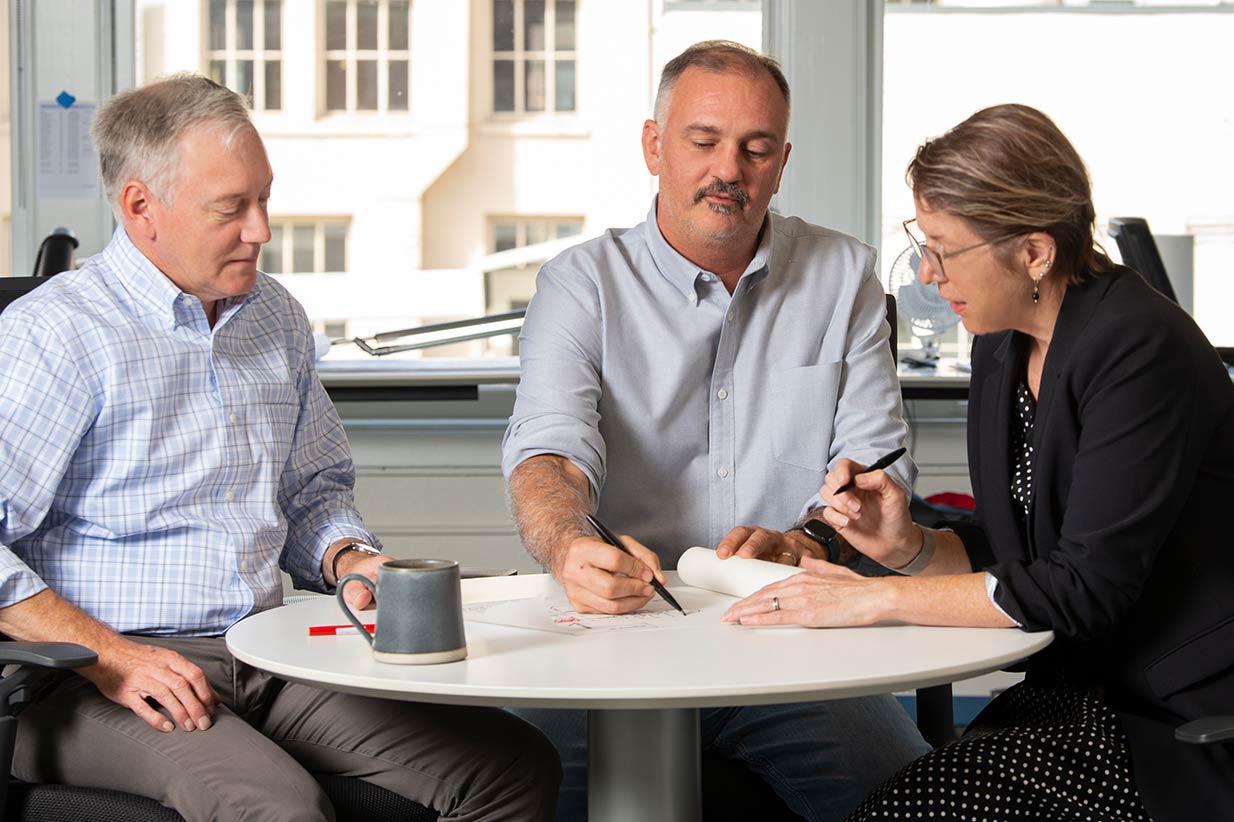 Two men and a woman sitting at table