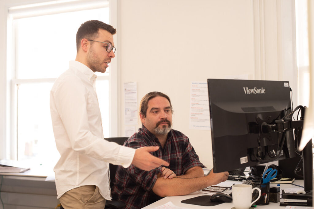 Two men working together at computer